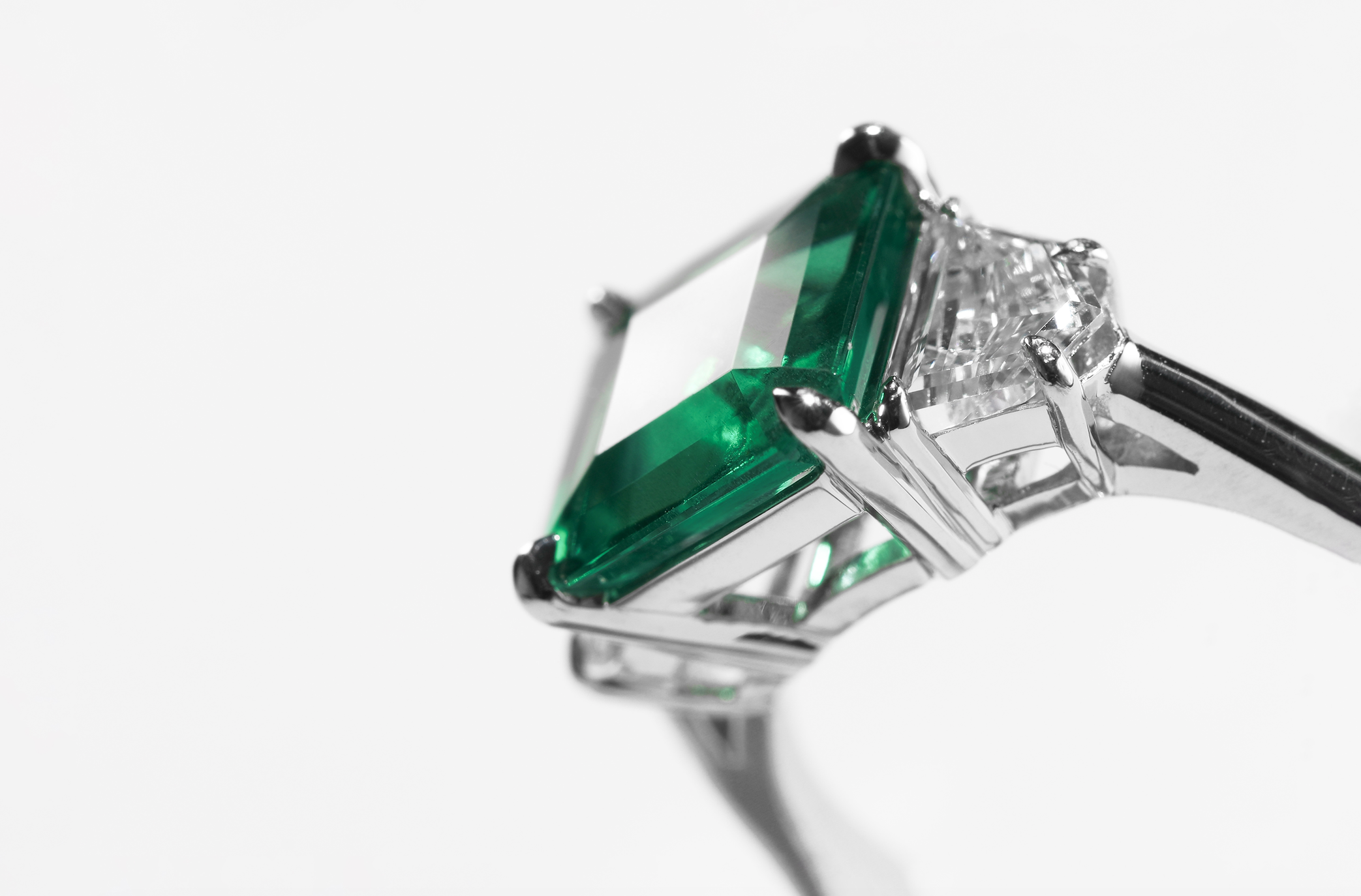 ILA SODHANI custom Emerald Trap Ring featuring an emerald trapped between two diamonds set in white gold.