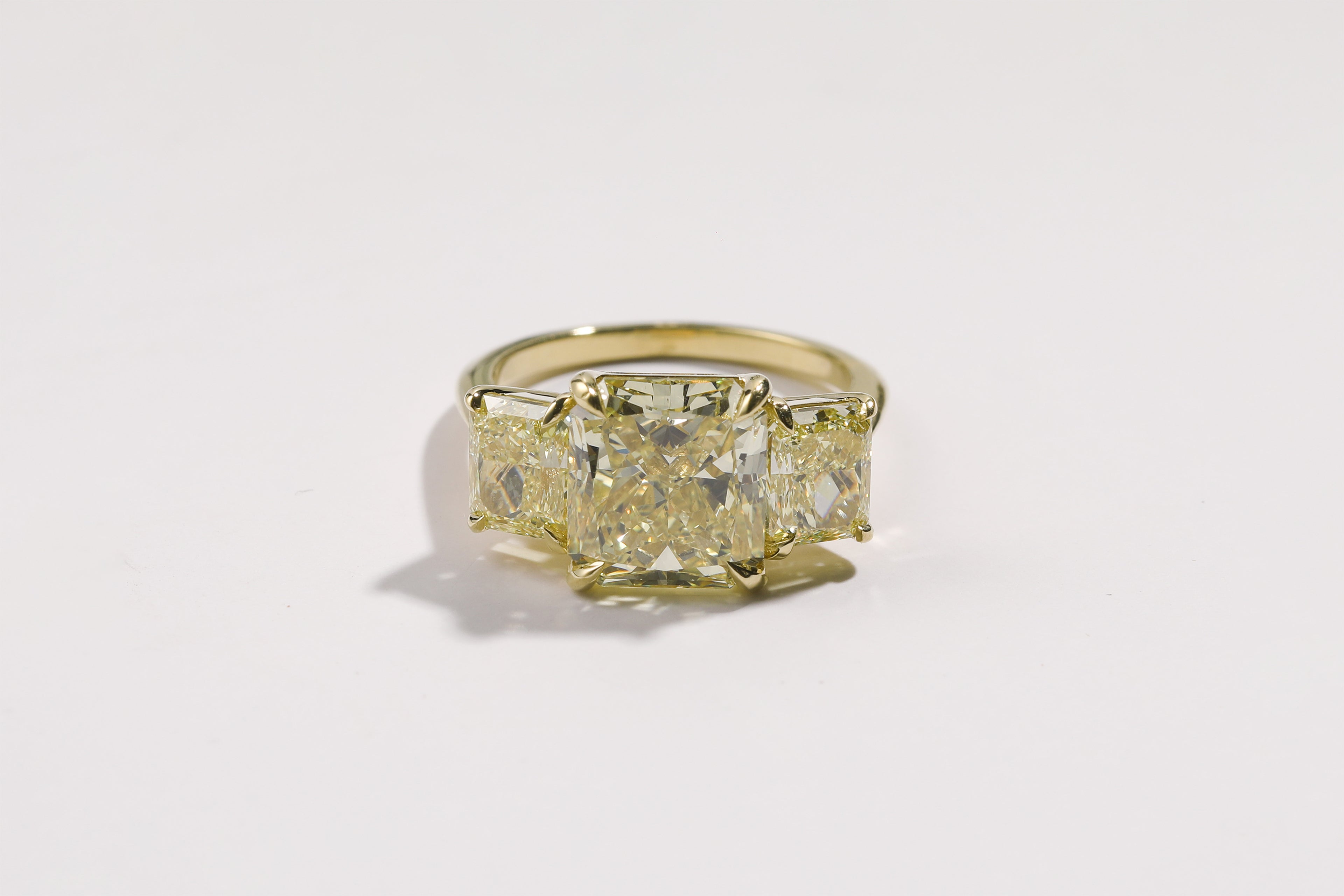 A custom ILA SODHANI Canary Diamond Trap Ring with hand selected natural canary radiant diamonds set in yellow gold.