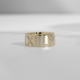 An ILA SODHANI Celebration Ring in yellow gold with white diamonds set into the roman numerals, "V.XII.LX"; shown in front of a white background.